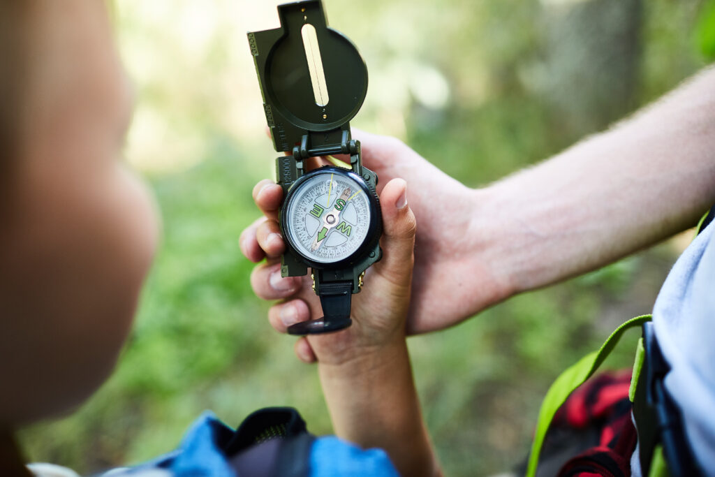 Hands,Of,Boy,Scouts,Holding,Compass,With,Arrow,Pointing,North